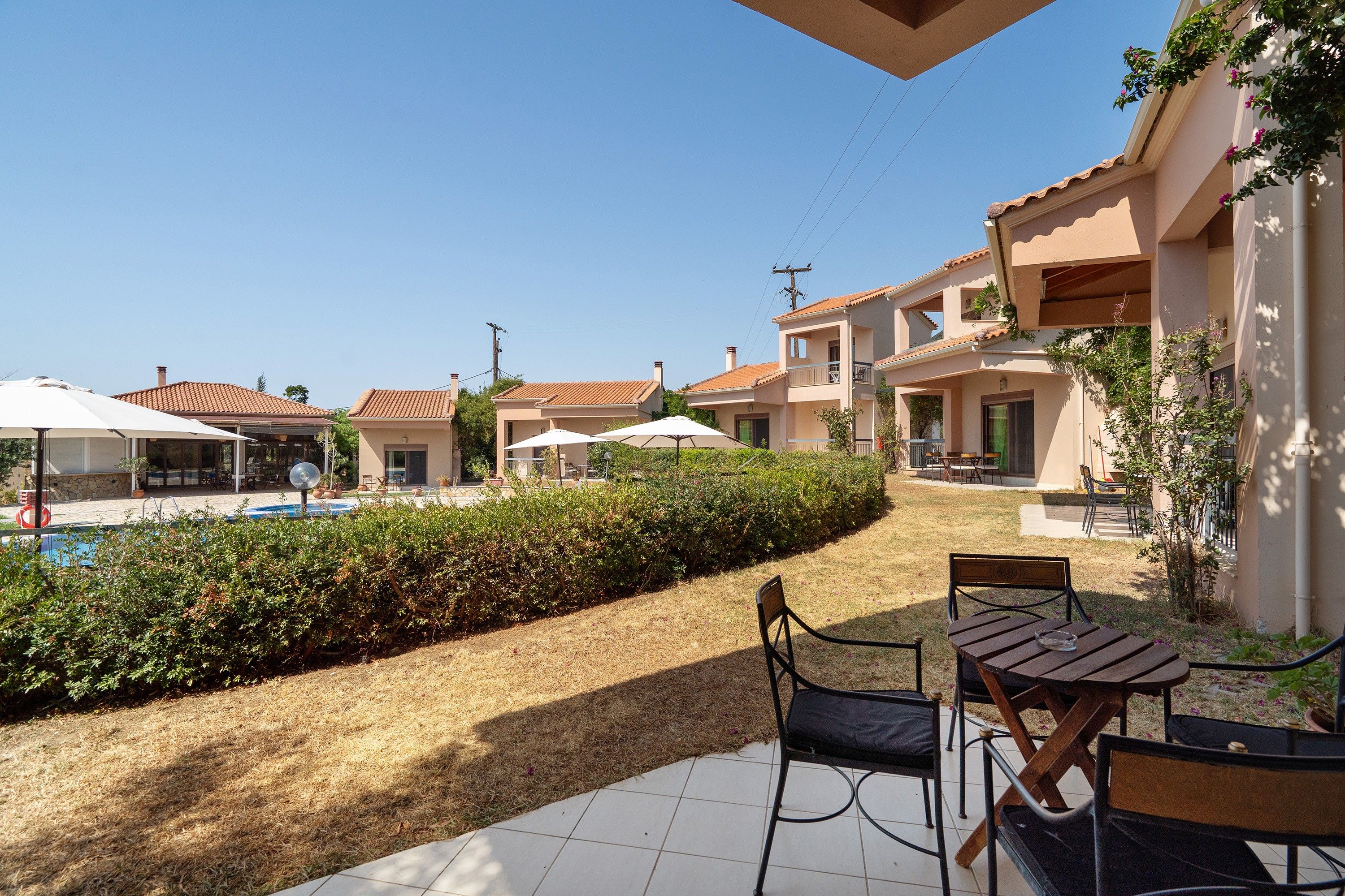 Zona residencial con piscina, mobiliario exterior y cielo despejado.