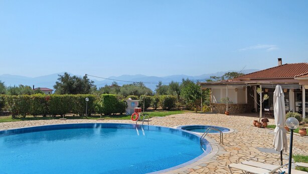 A swimming pool with a stone border, a lifebuoy, and lounge chairs. - Villa 'Kalirroe' in Marathiás (Marathiás)