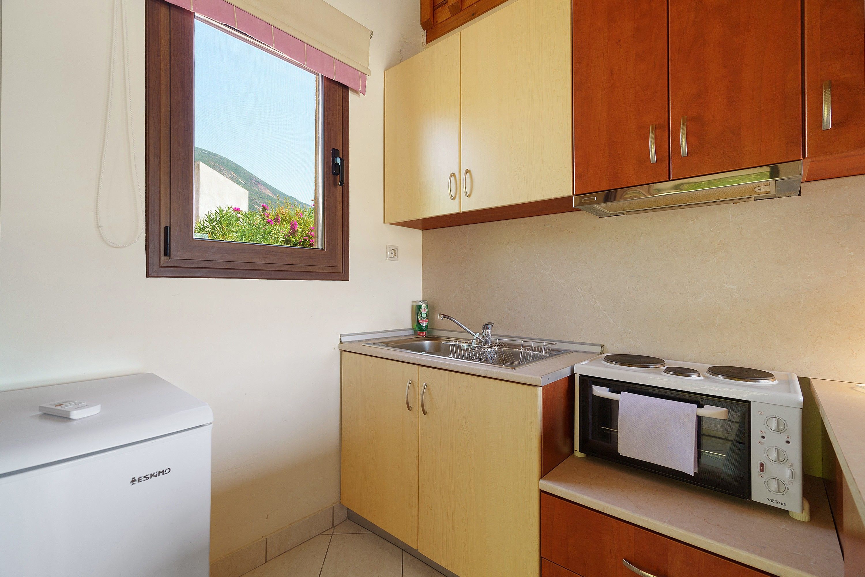 A compact kitchen with a built-in oven, a microwave, and a small refrigerator.