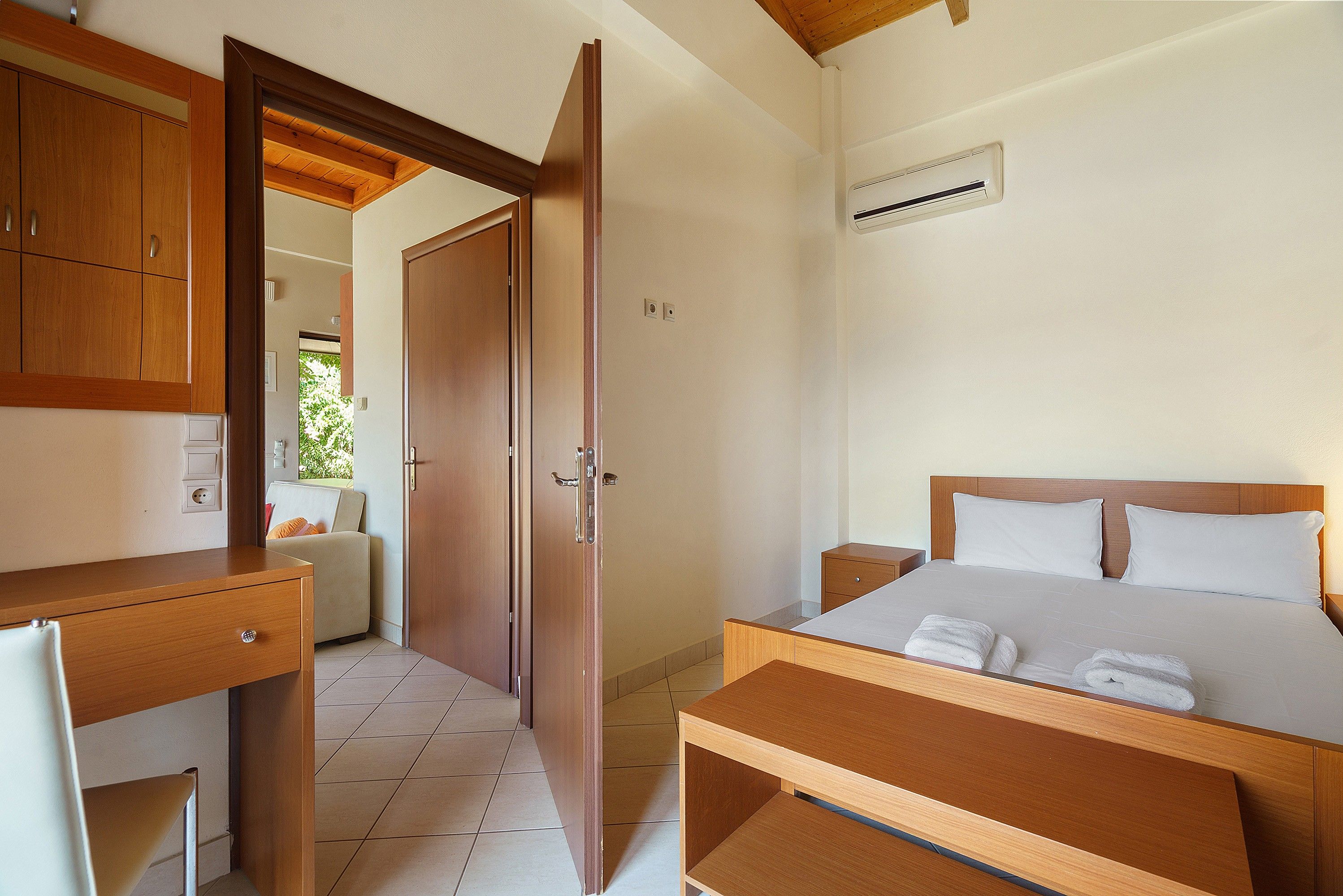 A bedroom with a bed, bedside tables, a desk, and a wardrobe.