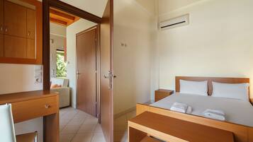 A bedroom with a bed, bedside tables, a desk, and a wardrobe.