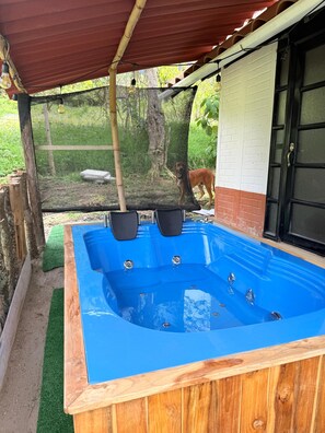 Ein Whirlpool mit Holzrahmen und einer roten Dachkonstruktion.