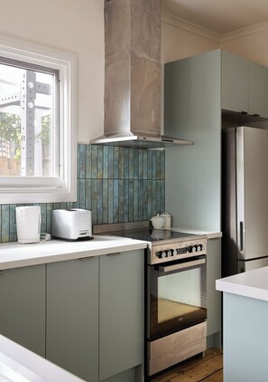 A kitchen with a built-in oven, a stainless steel range, and a window above the counter. - The Merri Creekside Living near Cafs and Culture (Northcote)