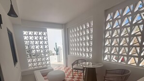 Un intérieur moderne avec un sol à carreaux, un espace piscine et un coin salon composé d’une table et de chaises.