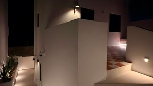 A modern building with a staircase leading to a second floor, a flat roof, and a light source on the wall. - Holiday Home 'Antiparos Moonstone Jacuzzi' with Wi-Fi and Air Conditioning (Antiparos)