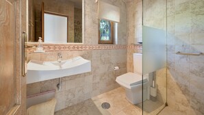 Un bagno con lavandino, toilette e box doccia in vetro.