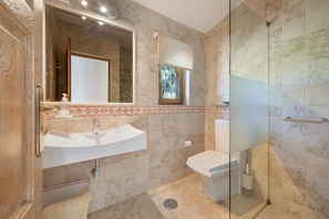 Ein Badezimmer mit Waschbecken, Toilette und Duschkabine aus Glas.