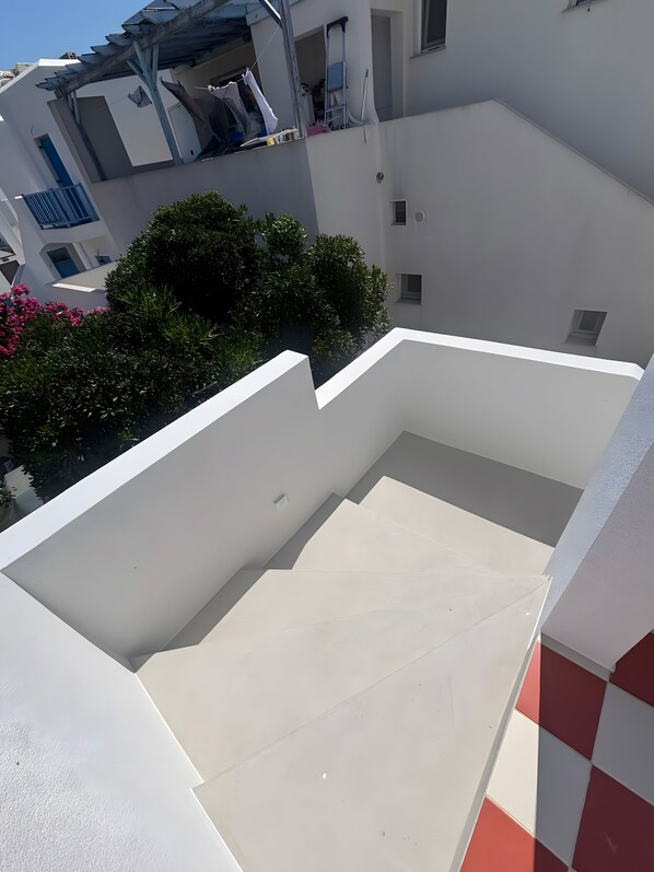A white building with a flat roof and a balcony area.