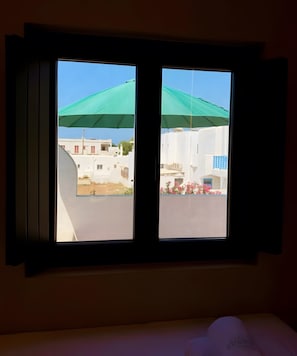 Ein Fenster mit Blick auf ein Wohngebiet, einschließlich Gebäude und einer grünen Baumdachschicht.