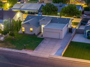 Un barrio residencial con casas, un camino pavimentado y un césped.