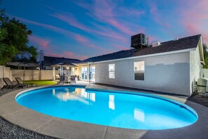 A residential swimming pool with a covered patio area, a garage, and a detached garage. - NEW|Desert Springs @Westgate|Designer Pool Retreat (Glendale)