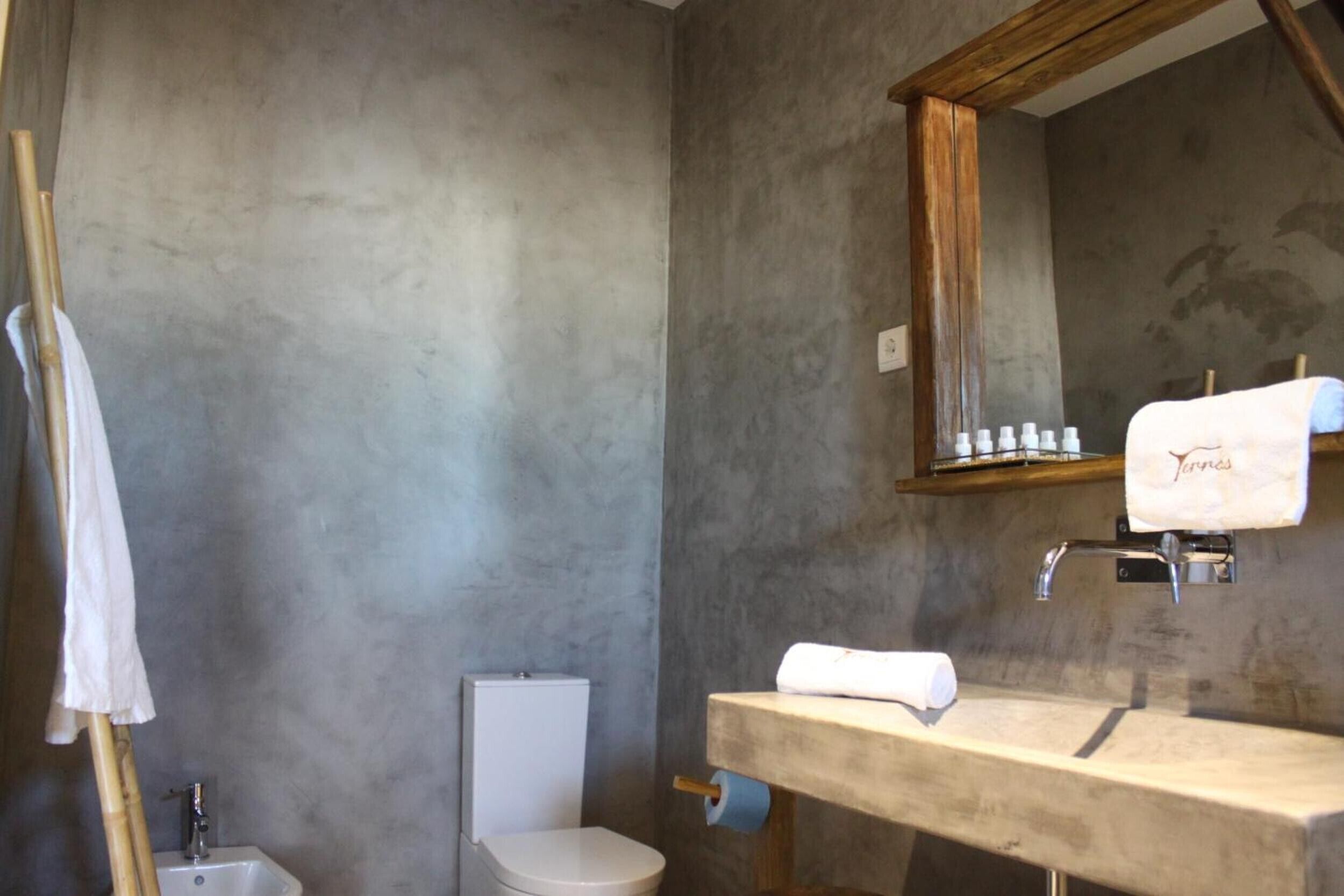 A bathroom with a toilet, sink, and mirror.