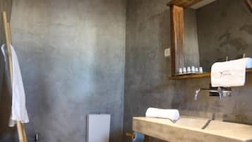 A bathroom with a toilet, sink, and mirror.