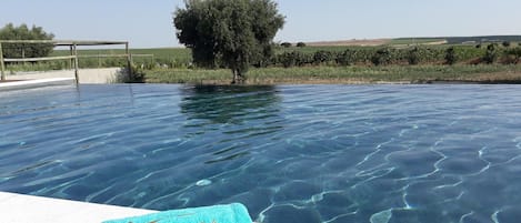A clear swimming pool with a single blue towel on the edge.