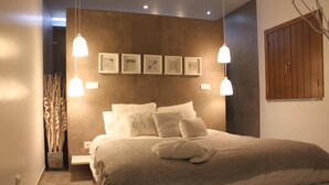 A bedroom with a large bed, two bedside tables, a nightstand, a wall-mounted wardrobe, and a hanging light fixture. - Terras Agroturismo & Vinhos: Tranquility Among Vineyards for Up to 8 Guests (Beja)