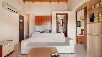 A modern living room with a sofa, a coffee table, and a kitchen area in the background.