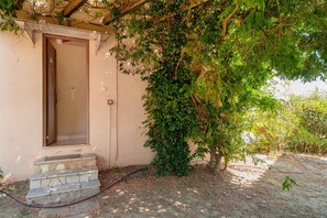 A building with a door and a small set of stone steps leading to a porch. - Villa 'Fedra' with Balcony and Air Conditioning (Marathiás)