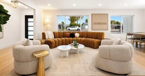 A modern living room with a sectional sofa, two armchairs, a coffee table, and a dining area with chairs. - NEW|The Hawthorne @ Kierland|Pool & Putting Green (Scottsdale)