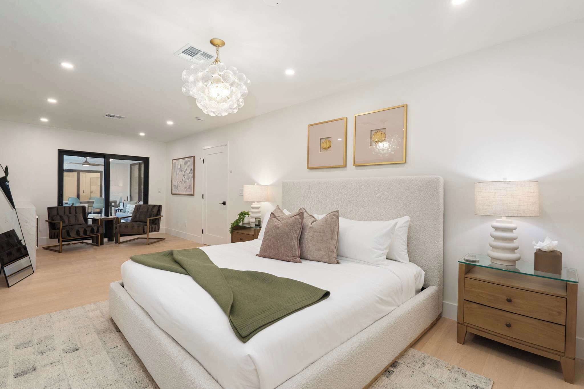 Un dormitorio moderno con una cama grande, mesitas de noche, un escritorio y una silla.