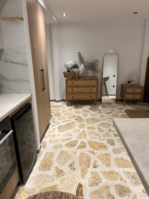 Cuina moderna amb un terra de disseny de pedra, armaris de fusta i un rentaplats integrat.
