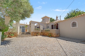 Um edifício em estilo mediterrâneo tradicional, com um pátio de pedra, paredes de pedra e arcadas.