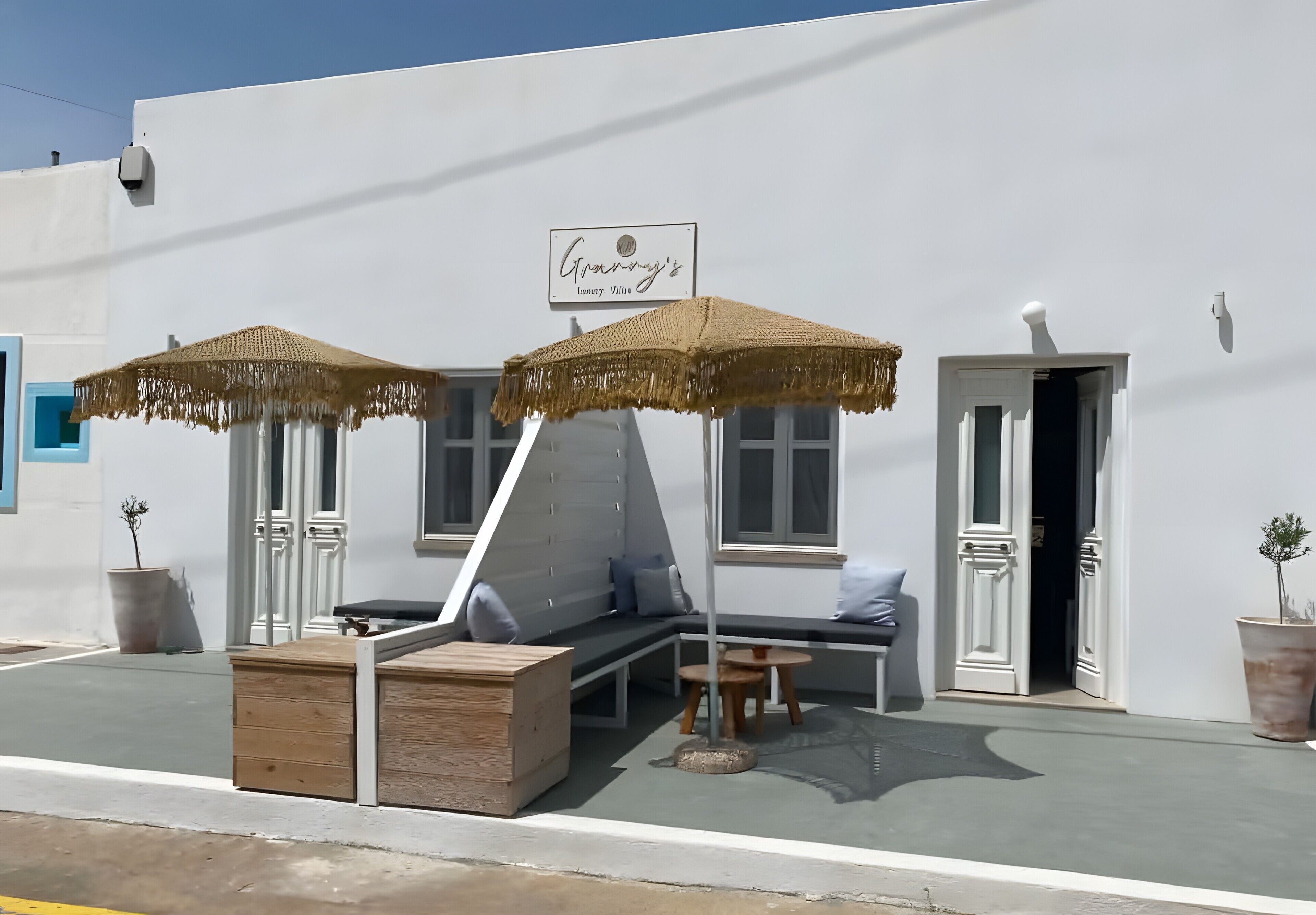 A building with a sign reading 'Greenway's' and a seating area with a table and chairs.