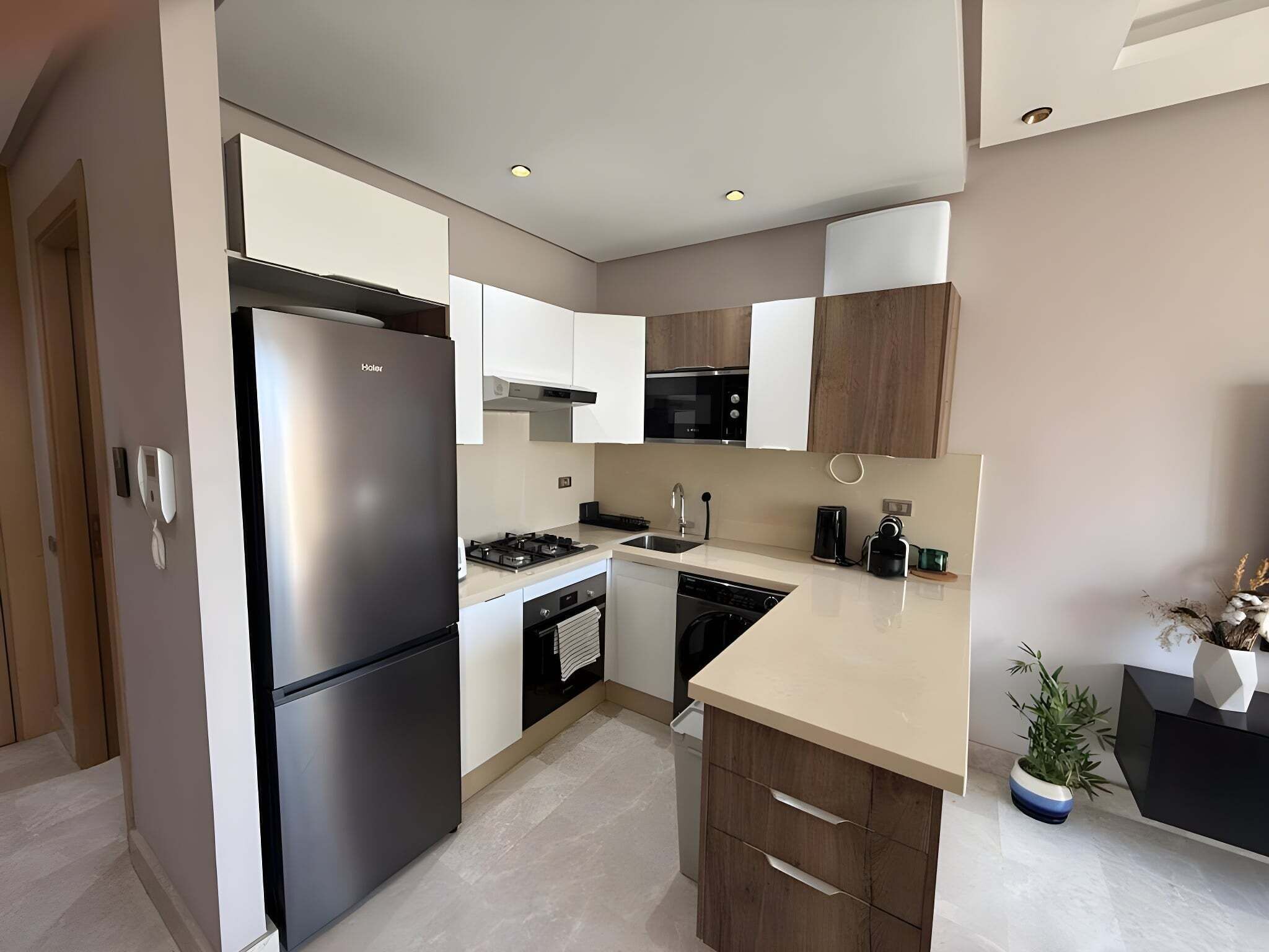 A modern kitchen with stainless steel appliances, wooden cabinets, and a central island.