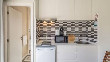 A compact kitchenette with a microwave, coffee maker, and a small sink.