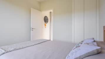 A bedroom with a bed, a door, and a wall-mounted decoration.