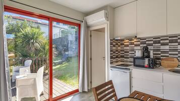 A modern kitchen with a microwave, coffee maker, and a wooden cutting board.