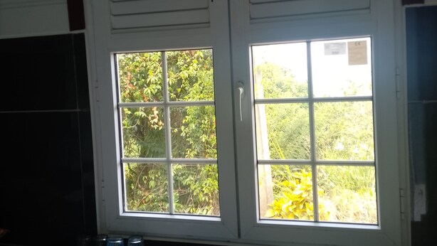 Keittiössä on kaksi allasta ja ikkuna, jossa on sälekaihtimet.