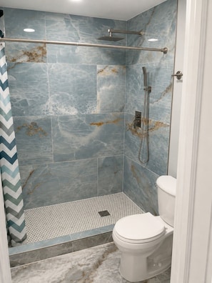 A shower with a glass door, a handheld showerhead, and a handheld showerhead. - Phenomenal 1-bedroom apartment with AC in Wilton Manors (Wilton Manors)