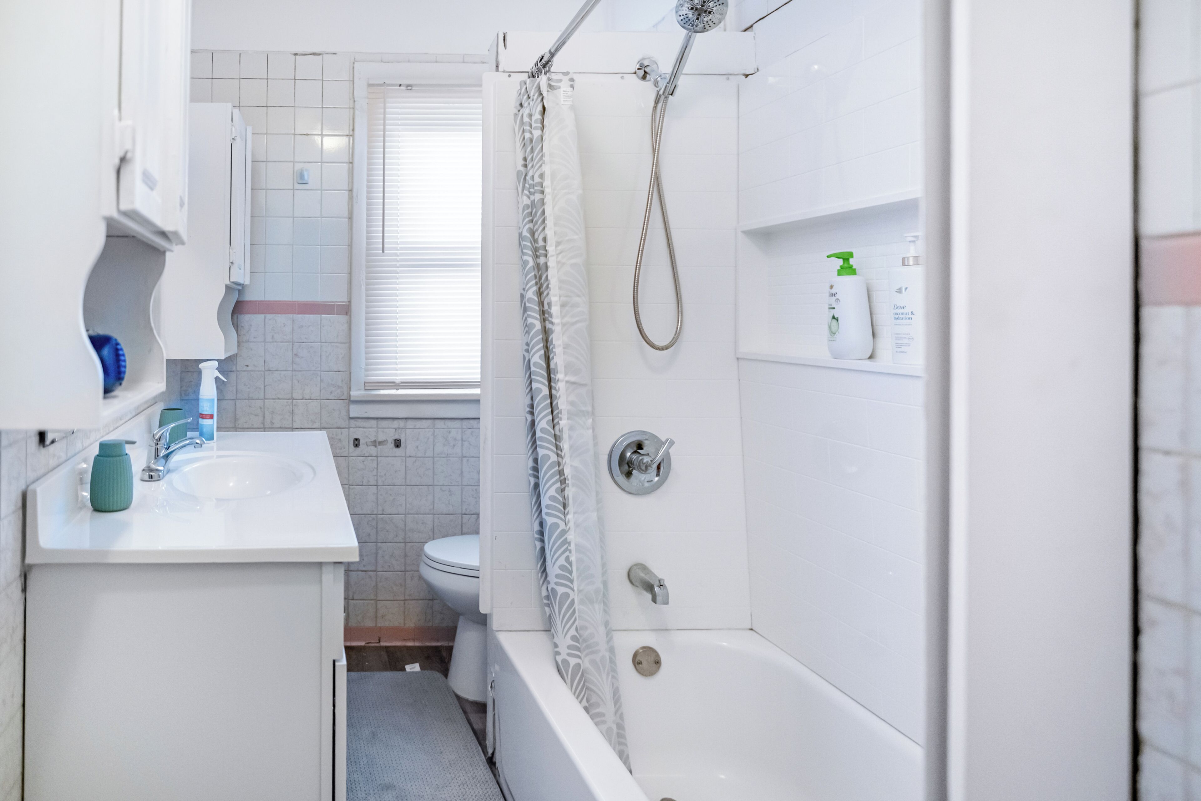 Een badkamer met douche, toilet, wastafel en een handdoekrek.