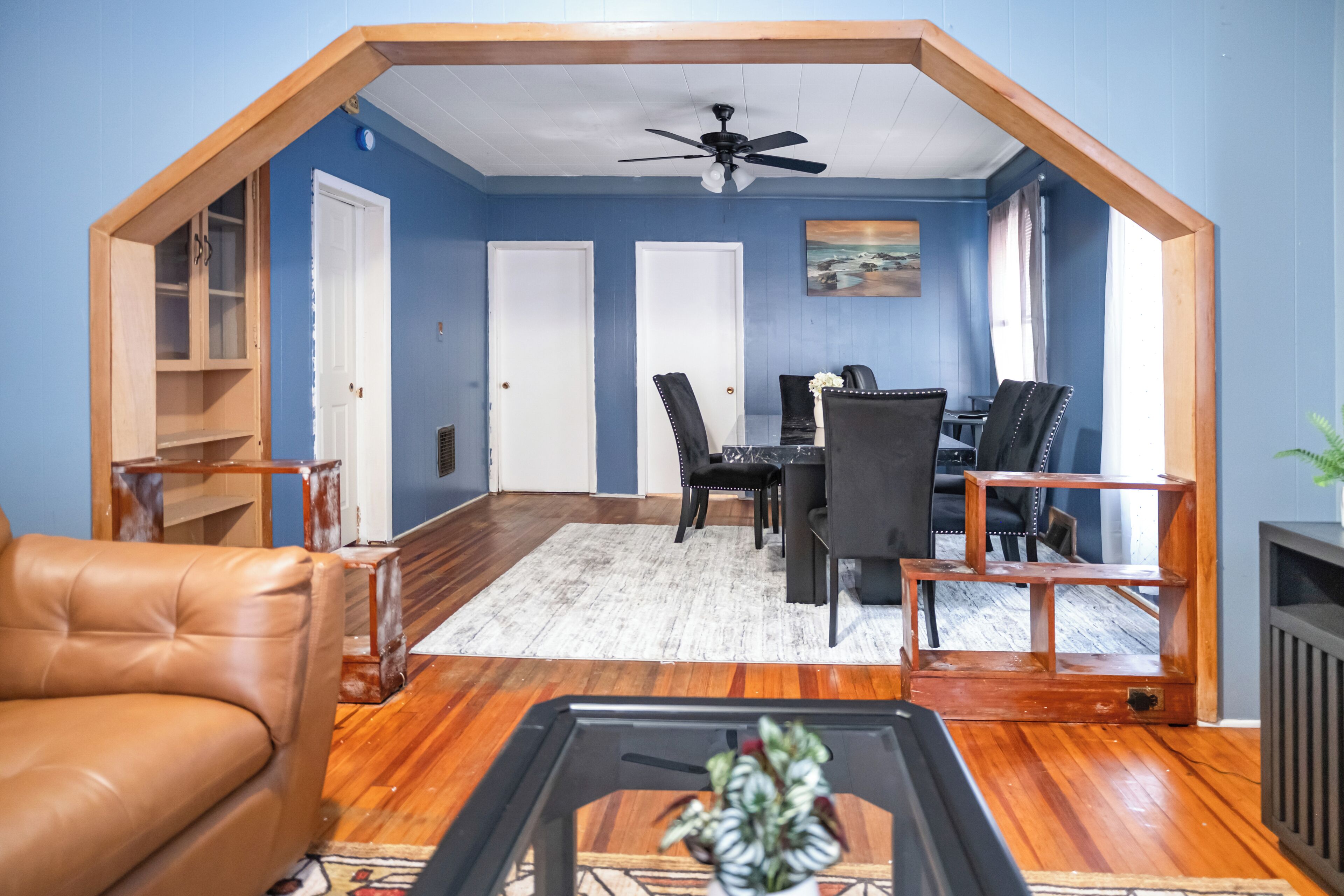 A room with a sloped ceiling, a dining table with chairs, a sofa, and a coffee table.