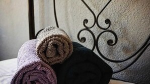 A bed with rolled towels in various colors.