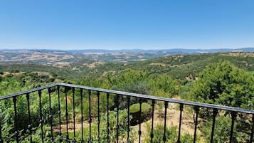 Varanda com vista para uma paisagem montanhosa.