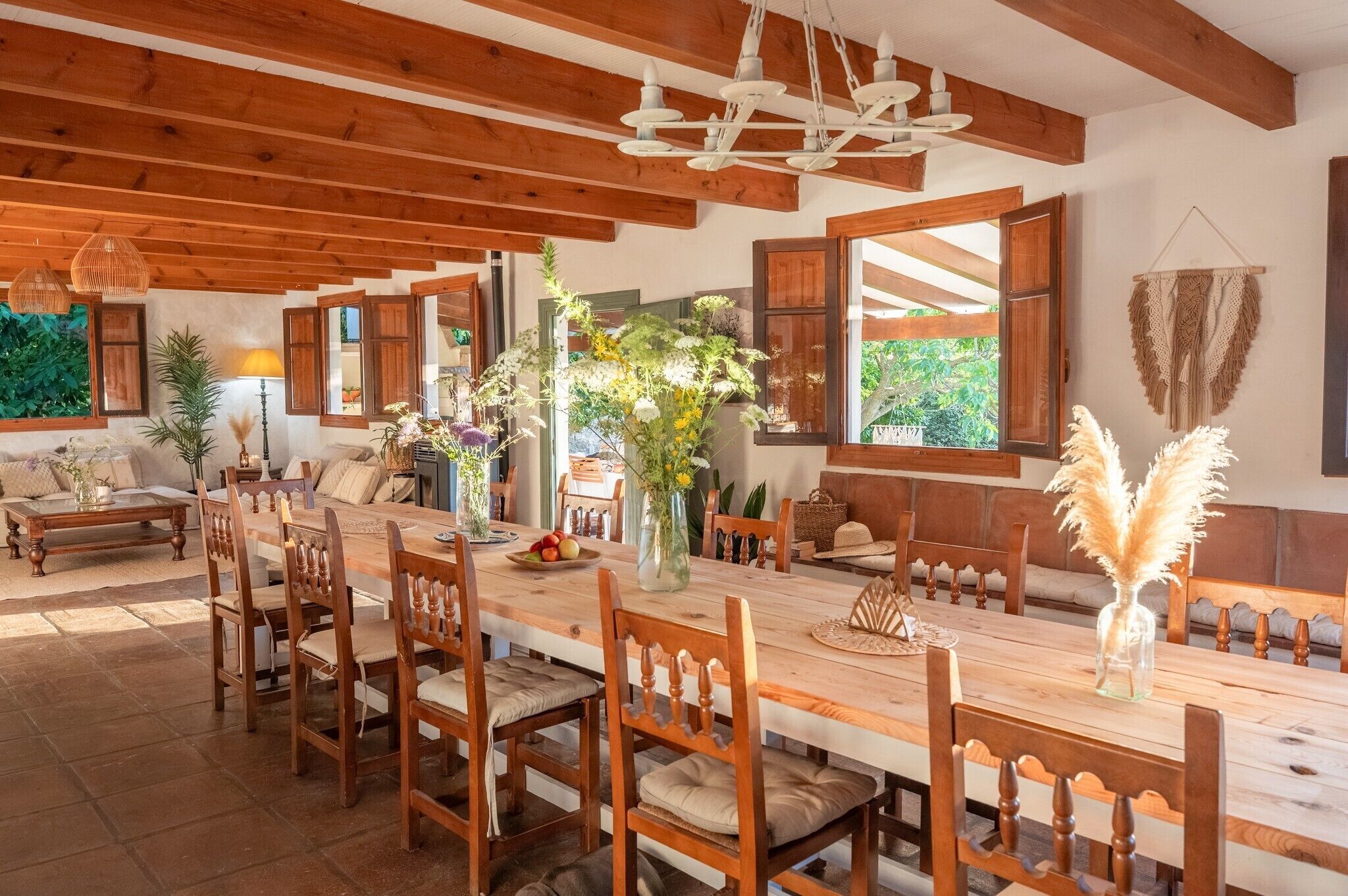 A dining area with wooden furniture, a large table, and a hanging light fixture.