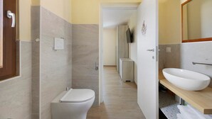 Une salle de bain moderne avec des toilettes, un lavabo et un miroir.