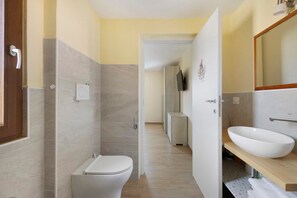 A modern bathroom with a toilet, sink, and mirror. - Relaxing Room Surrounded by Nature (Pontremoli)