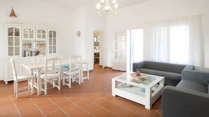 A spacious living room with a dining area, a sofa, and a coffee table.