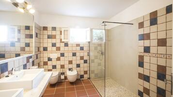 Een badkamer met een douche, toilet en wastafel.