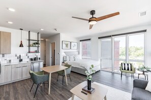 A modern hotel room with a kitchen, dining area, and a large bed. - Modern Stay | 1 Unit | Central Huntsville Location (Huntsville)