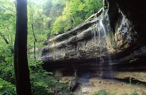 A natural rock formation with a waterfall in a forested area. - Modern Huntsville Stay | 1 Unit | Central Location (Huntsville)