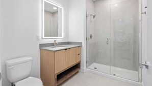 Ein modernes Badezimmer mit Toilette, Waschtisch und einer Duschkabine.