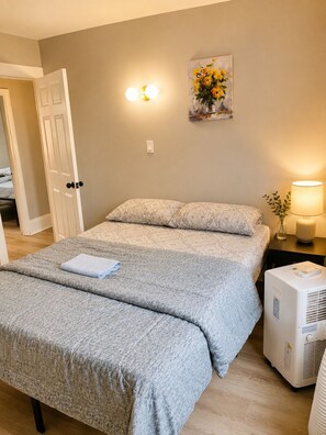 Une chambre à coucher avec un lit double, une table de chevet avec une lampe et un luminaire fixé au mur.