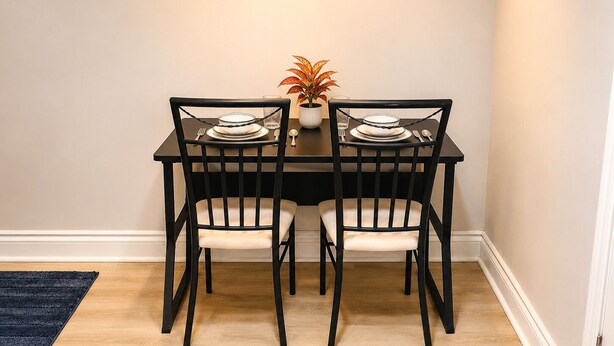 A dining table with four chairs, a potted plant, and a candle on the table.