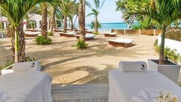A beachside lounge area with sun loungers and a wooden deck.