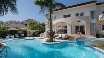 A swimming pool with lounge chairs and a palm tree.
