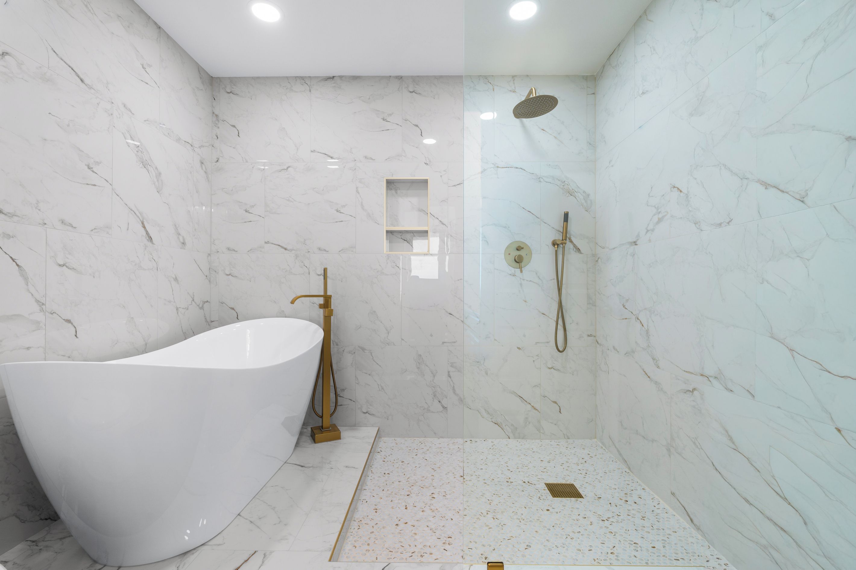 A modern bathroom with a freestanding bathtub, a walk-in shower with a handheld showerhead, and a marble-tiled wall.