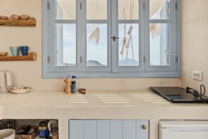 A kitchen with a large window, a coffee maker, and various kitchen utensils.